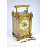A 19th century Gothic style gilt cased carriage clock, the white ceramic dial within an engraved