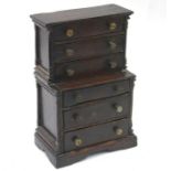 An antique oak miniature chest on chest with six long graduated drawers with brass pulls, 23 cm w