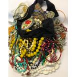 A large collection of vintage and later costume jewellery including beads, brooches, paste set