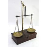 An early 19th century set of brass and steel scales, mounted on a mahogany box base with drawer,