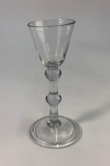 An 18th century style cordial glass, rounded funnel bowl, straight stem with shoulder and central