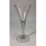 A 19th/20th century tall wine glass, drawn trumpet bowl, plain stem, conical foot and rough