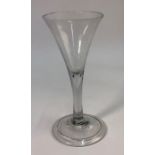 An 18th century wine glass, drawn trumpet bowl, plain stem incorporating a tear drop, domed folded