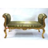 A Georgian style giltwood framed window seat with scroll ends, upholstered in green satin, raised on