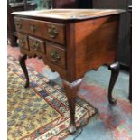 An 18th century oak side table with one long over three short drawers, raised on four cabriole legs,