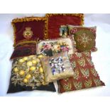 A pair of red velvet cushions with armorial crests and yellow tassels, four wool tapestry