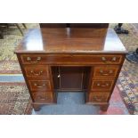 A 19th century mahogany kneehole desk with an arrangement of seven drawers around a recessed