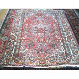 A fine Persian Isfahan rug, stylised floral design on red ground with alternating palmette and