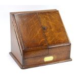 A Victorian oak table top stationery box, the pair of slope front doors enclosing a graduated