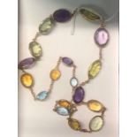 A riviere necklace formed of graduated oval coloured gemstones including aquamarine, citrine,