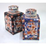 An associated pair of Japanese Imari vases of square section; each one with domed cover, marked with