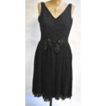 A Frank Usher black lace cocktail dress with pleated skirt and beaded bow detail to waist, 46 cm