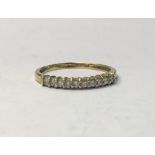 A 9ct yellow gold narrow ring set with ten brilliant claw set diamonds, stamped 0.25pts, size L,
