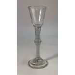 An 18th century style cordial glass, round funnel bowl, tall multi spiral opaque and air twist