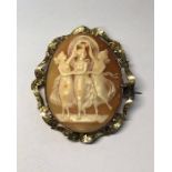 A large antique oval shell cameo featuring the Three Graces, in scroll foliate yellow gold mount,