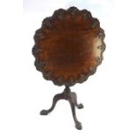 A mahogany tripod table in the 18th century style, the circular pie crust and carved tilt-top raised