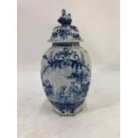 A Dutch Delft blue and white octagonal fluted vase and cover painted with a lady and a gentleman