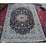 An Indo-Persian part silk Ispahan rug, the floral design on blue ground within camel ground borders,