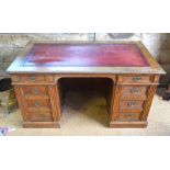 A late 19th century oak/pollard oak twin pedestal desk, the top with inset tooled rouge leather