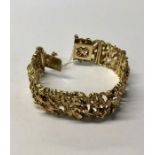 A 1970s style 9ct yellow gold bracelet formed of eight textured panels, with concealed clasp and