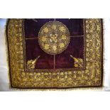 An early 1900s Sri-Lankan deep red velvet panel richly embroidered with gold metallic thread in