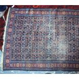An antique Persian Senneh rug, the repeating field of geometric designs on blue ground, 147 cm x 106