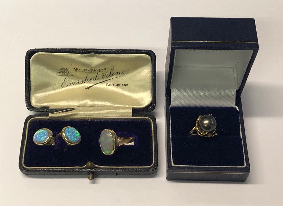 A yellow metal ring set oval opal, stamped 9ct, size K and a pair of opal set clip on earrings to/