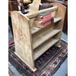 A vintage limed oak library book carrier, with three back to back graduated open shelves, on