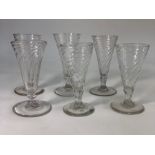 Six 18th/19th century short ale glasses with conical wrythen bowls, short knop stems, rough pontils,