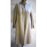 A dove grey wool coat with dark grey stripe and tie-toggle detail to neck and cuffs retailed by