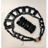 An Art Deco style black jet necklace formed of rectangular plaques, round beads and oval beads, to/w