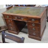 A late Victorian twin pedestal mahogany desk, the green  tooled leather top over an arrangement of