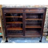 A late 19th century continental walnut glazed library bookcase, the pierced brass 3/4 gallery top