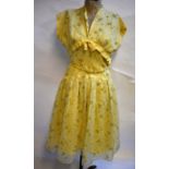 A 1950s pale yellow dress with flocked yellow/green rose sprays and bow detail to bodice, Peggy