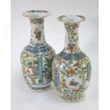 A pair of Chinese polychrome vases; each one decorated with panels of Manchu/Chinese figures in