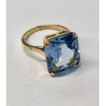 A large blue topaz rectangular single stone ring, claw set, yellow metal, size R, 1.5 x 1.3 cm,