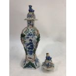 An 18th century Delft polychrome square baluster vase and cover decorated with a Chinese man in a