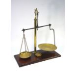 A set of brass pillar balance scales on a mahogany base, to/w a set of seven graduated weights (