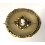A large Victorain oval chalcedony brooch with gilt metal scroll mount and small oval cameo and