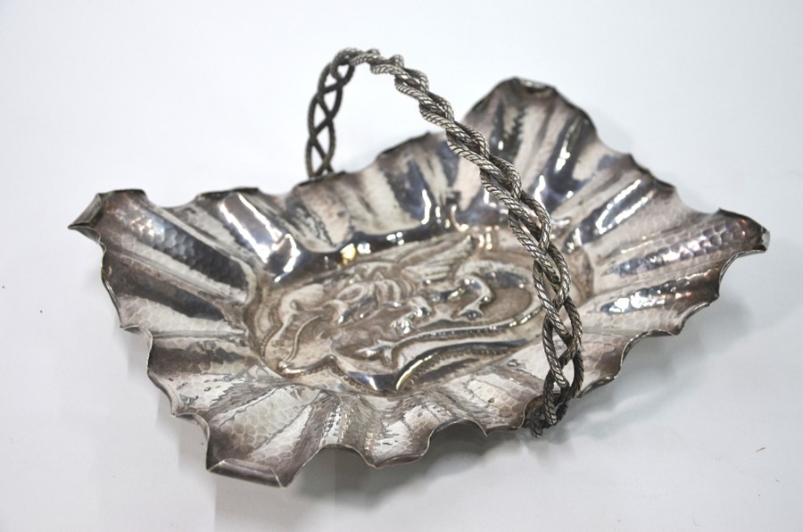 An Arts & Crafts style rectangular dish embossed with a dragon within a hammered and crenelated rim,