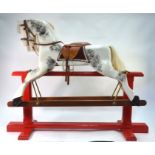 A traditional handmade wooden rocking horse fitted with studded leather saddle and reigns, horse