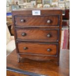 A mahogany miniature chest of four long drawers