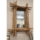 A rustic layered stick framed wall mirror