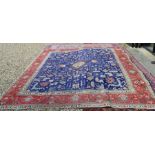 A Persian Tabriz carpet with stylised floral design on violet ground, red border with ivory