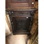 An antique carved oak floor standing oak corner cupboard