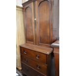A mahogany cabinet on chest with a pair of panelled cupboard doors over three long drawers raised on