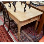 An old stripped pine writing table with end drawer, raised on turned supports