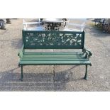 A green painted metal rose cast garden bench with slatted seat