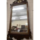 A mahogany fret-cut wall mirror surmounted by a ho-ho bird