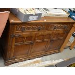 An Old Charm style carved oak sideboard with two drawers over panelled cupboard doors